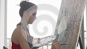 Young elegant woman painting at her workshop