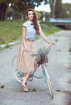 Young elegantly dressed woman with bicycle, summer and lifestyle