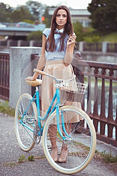 Young elegantly dressed woman with bicycle, summer and lifestyle