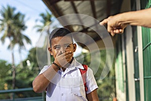 A young elementary student feels embarrassed after being scolded by an old man for loitering outside the school or being late. At