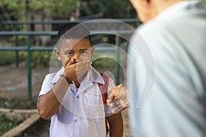 A young elementary student feels embarrassed after being scolded by an old man for loitering outside the school or being late. At