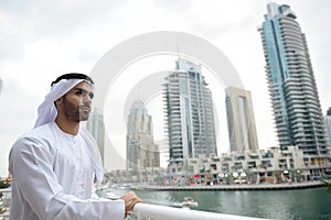 Young Emirati arab man standing by the canal