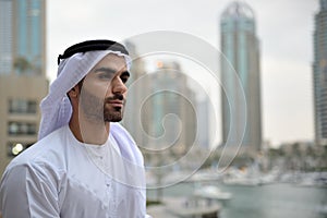 Young Emirati arab man standing by the canal photo