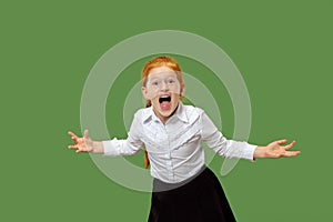 The young emotional angry teen girl screaming on green studio background