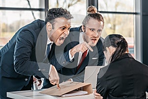 Young emotional businesspeople in formalwear arguing at meeting in office