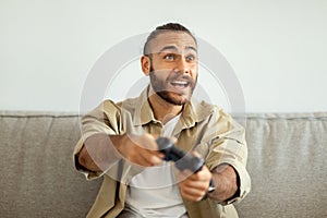 Young emotional man playing video games at home