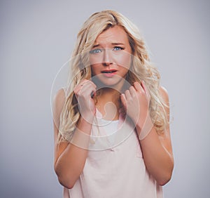 Young emotional woman, isolated on gary background