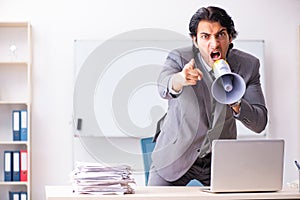 The young employee boss with megaphone in the office