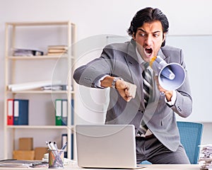 Young employee boss with megaphone in the office