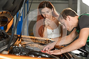 A young employee of the car service centers shows a beautiful gi