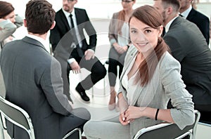 Young employee in the circle of like-minded business meeting