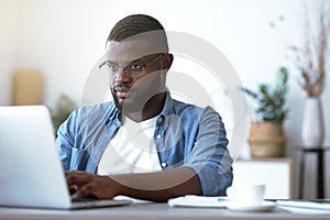 Young employee looking at computer monitor during working day in office