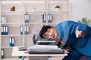 Young employee making copies at copying machine