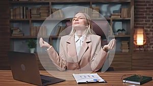 Young employee meditating after working on laptop