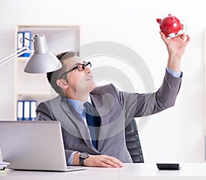 Young employee with piggybank in pension savings concept