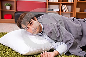 The young employee sleeping on the floor at office