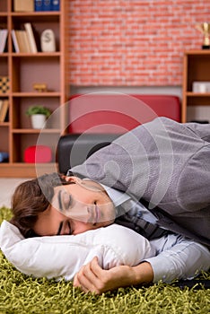 The young employee sleeping on the floor at office