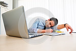 Young employee sleeps at workplace