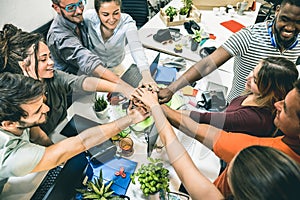 Young employee startup workers group stacking hands at start up office