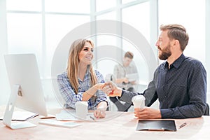 Young employees with coffee glasses sitting at the Desk