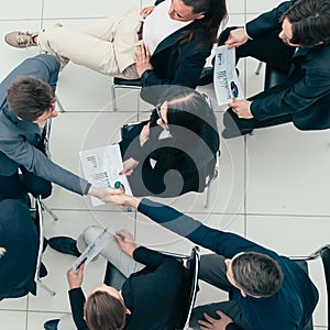 young employees supporting each other with a handshake.