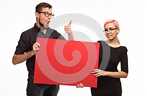 Young encouraged couple showing presentation pointing placard