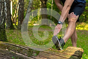 A young enduring athletic athlete is doing stretching in the forest outdoors, around the forest, oak trees.run forest