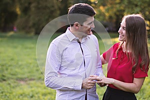 Young engaged couple outdoors in the park