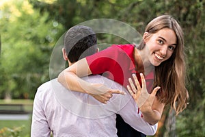 Young engaged couple outdoors in the park. Engagement ring