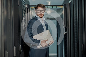 Young it engeneer business man with thin modern aluminium laptop in network server room