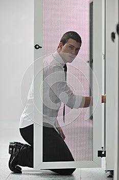 Young engeneer in datacenter server room