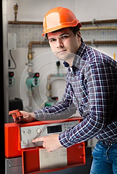 Young engineer adjusting system work on control panel