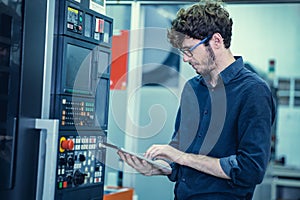 Young Engineer American professional staff worker operate advance machine with tablet computer