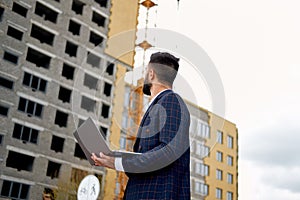 Young Engineer or Architect working with laptop computer a at construction site. Engineering and building construction concepts