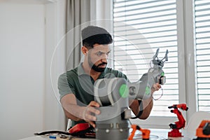 Young engineer building and programming a robotic arm at home.