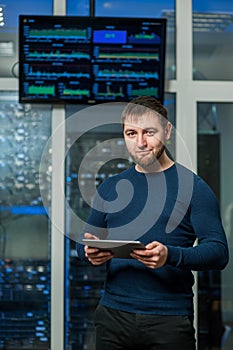 Young engineer businessman with the tablet in network server room