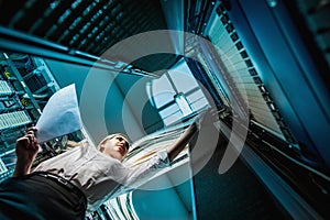 Young engineer businesswoman in network server room