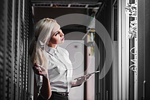 Young engineer businesswoman in network server room