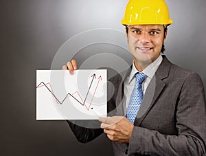 Young engineer drawing a rising graph, representing business growth