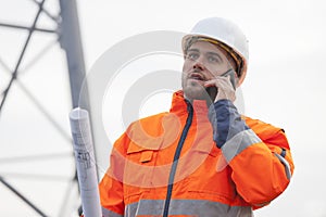 Young engineer or foreman talking  on smart phone on a oil platform or construction site