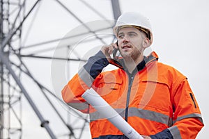 Young engineer or foreman talking  on smart phone on a oil platform or construction site