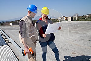 Young engineer girl and skilled worker on a roof