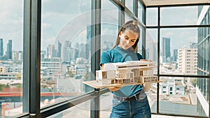 Young engineer hold architectural model while inspect house model. Tracery