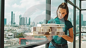 Young engineer hold architectural model while inspect house model. Tracery