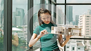 Young engineer hold architectural model while inspect house model. Tracery