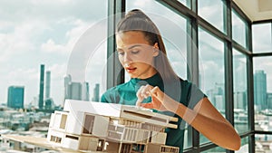 Young engineer hold architectural model while inspect house model. Tracery