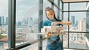 Young engineer hold architectural model while inspect house model. Tracery