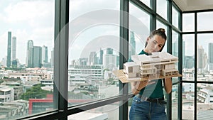 Young engineer hold architectural model while inspect house model. Tracery