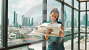 Young engineer hold architectural model while inspect house model. Tracery