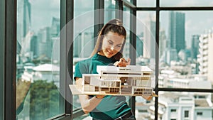 Young engineer hold architectural model while inspect house model. Tracery